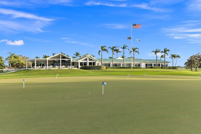 view of property's community with view of golf course and a yard