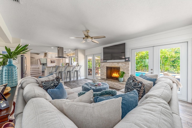 living area with wood finished floors, plenty of natural light, and french doors