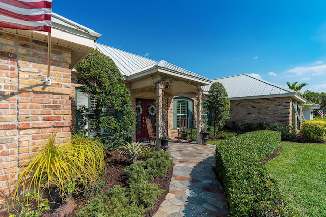 property entrance featuring brick siding, metal roof, and a standing seam roof