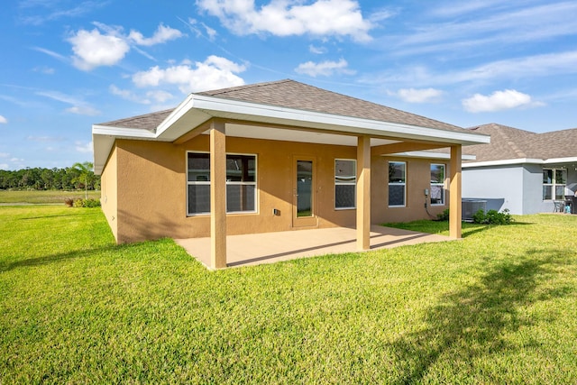 back of property featuring stucco siding, a lawn, central AC, and a patio area