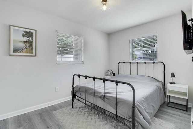 bedroom featuring wood finished floors and baseboards