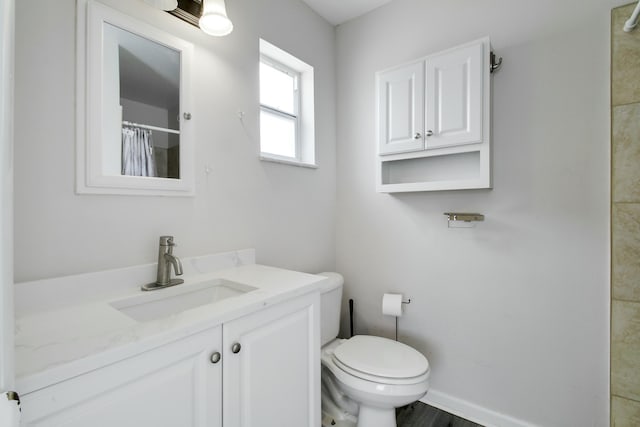 full bath with vanity, curtained shower, toilet, and baseboards