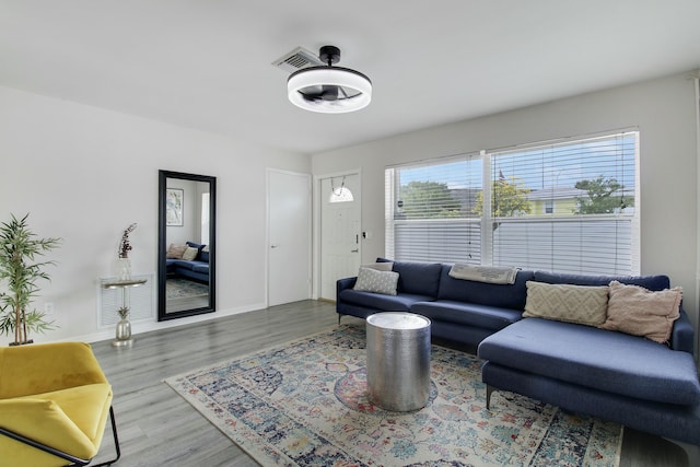 living area featuring visible vents, baseboards, and wood finished floors