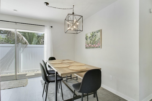 dining room featuring a notable chandelier, baseboards, and wood finished floors