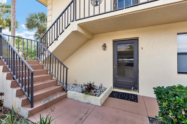 doorway to property featuring stucco siding