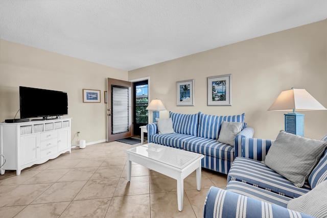 living room with light tile patterned floors, baseboards, and a textured ceiling