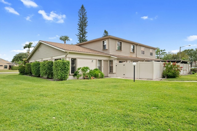 rear view of house with a yard and fence