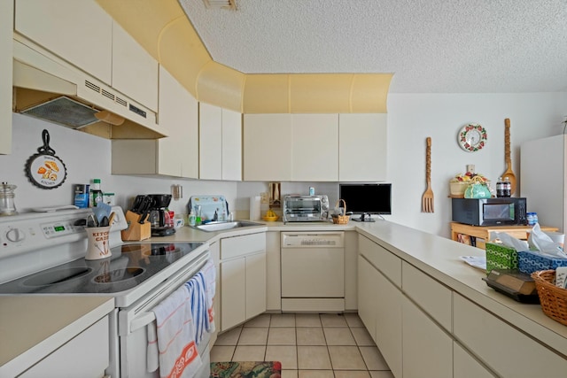 kitchen with white appliances, light tile patterned floors, light countertops, and a textured ceiling