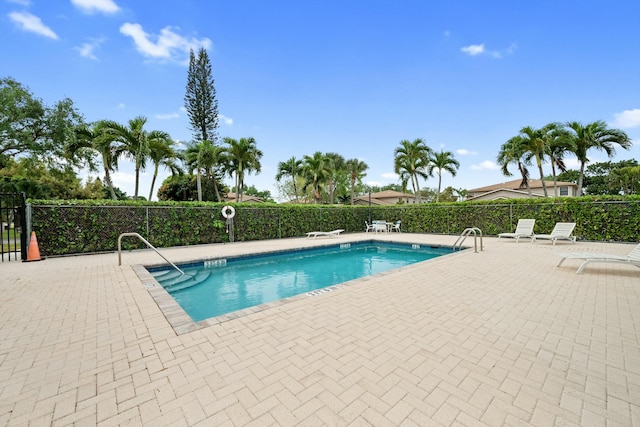 pool with a patio area and fence