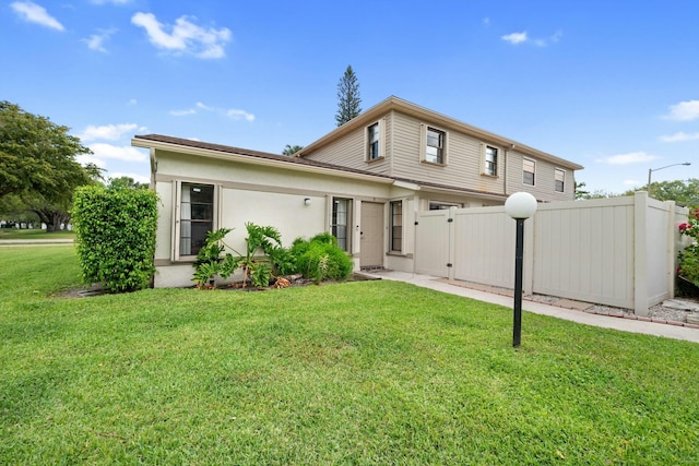 view of front of property featuring fence, a front lawn, and a gate