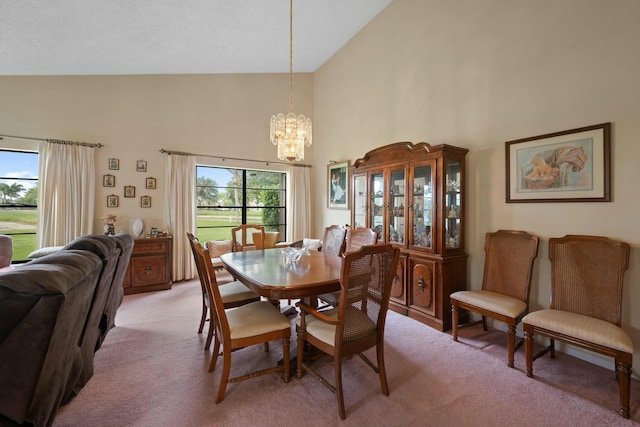 dining room with light colored carpet, an inviting chandelier, and high vaulted ceiling