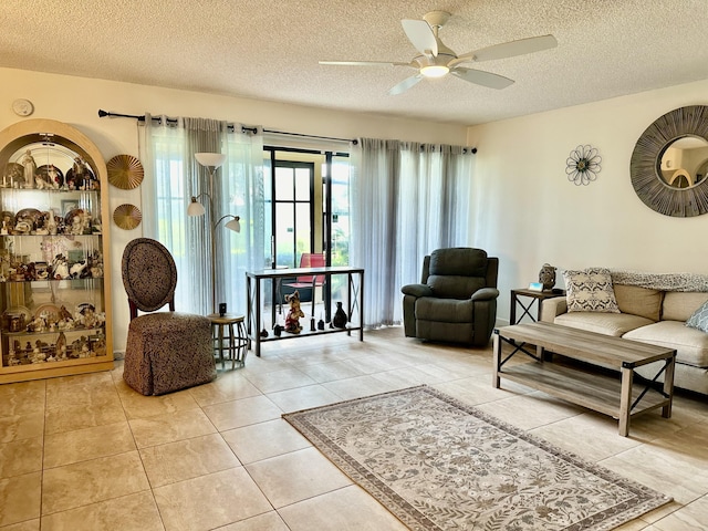 living room with ceiling fan, tile patterned flooring, and a textured ceiling
