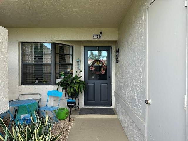 entrance to property featuring stucco siding