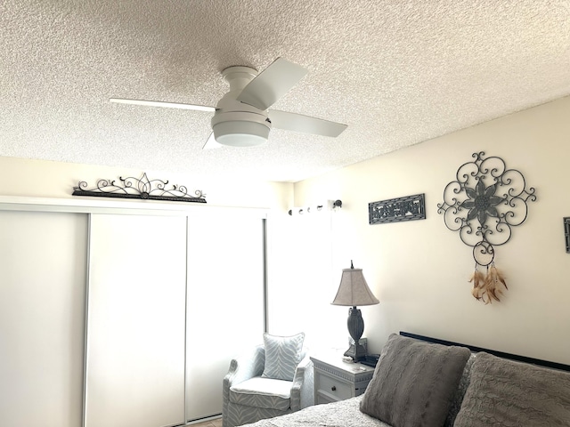 bedroom featuring a closet, a textured ceiling, and ceiling fan