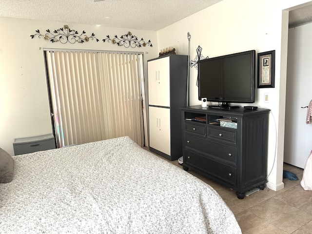 bedroom with light tile patterned flooring and a textured ceiling