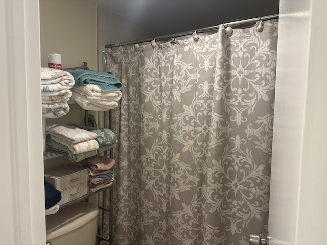 full bath featuring a shower with curtain and toilet