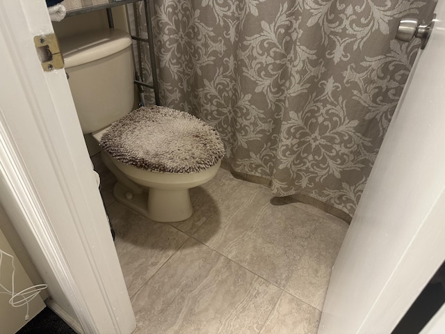 bathroom with toilet and tile patterned flooring
