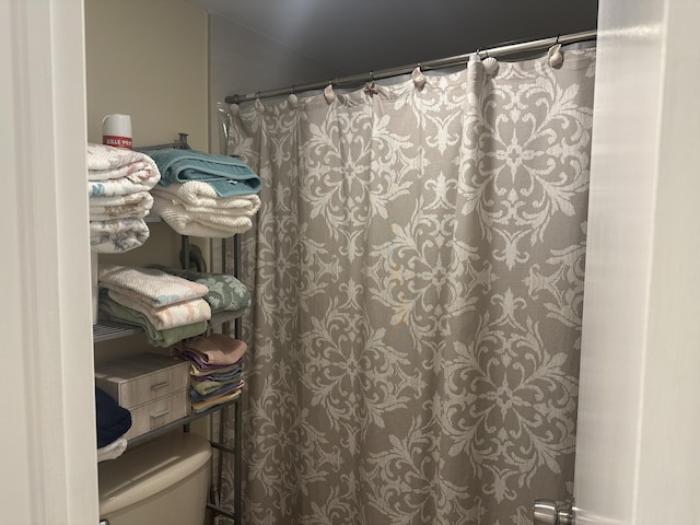 full bathroom with a shower with shower curtain and toilet