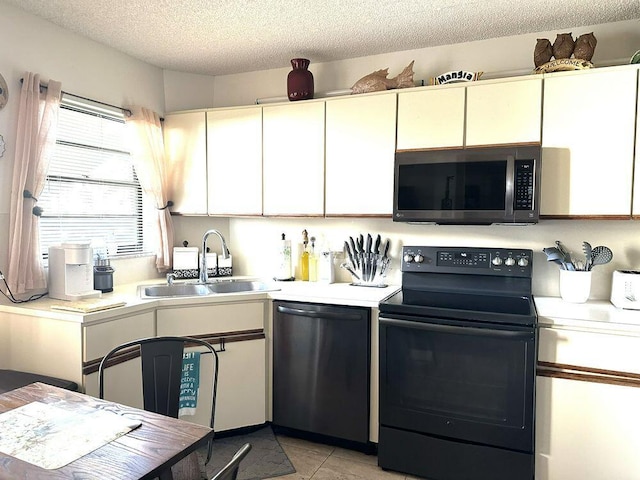 kitchen with a sink, a textured ceiling, appliances with stainless steel finishes, and light countertops