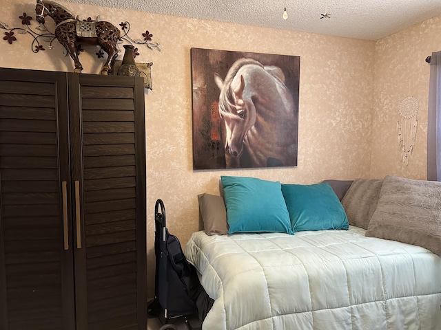 bedroom with wallpapered walls and a textured ceiling