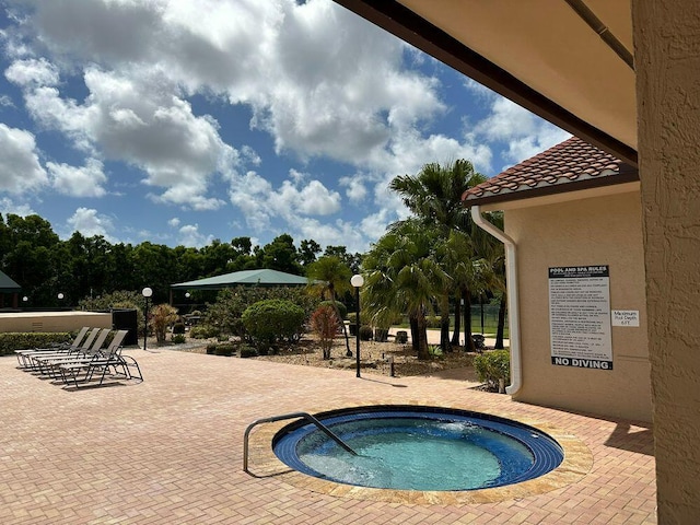 view of pool with a hot tub