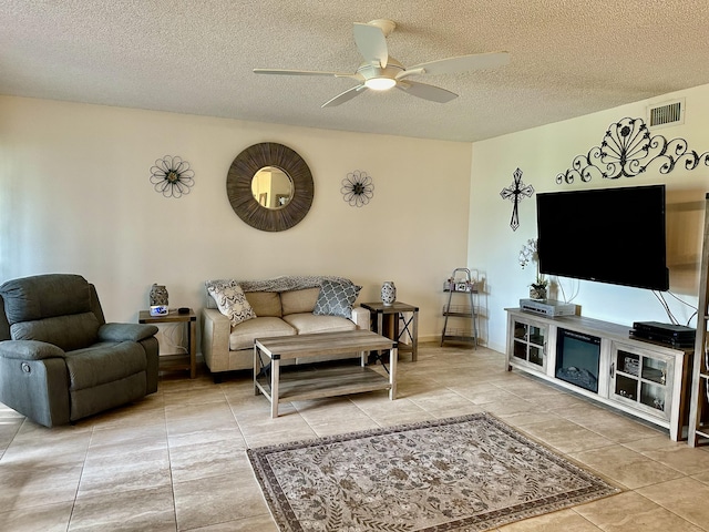 tiled living room with visible vents, a textured ceiling, and ceiling fan