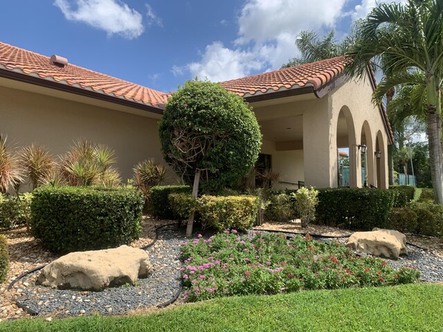 exterior space with a tiled roof and stucco siding