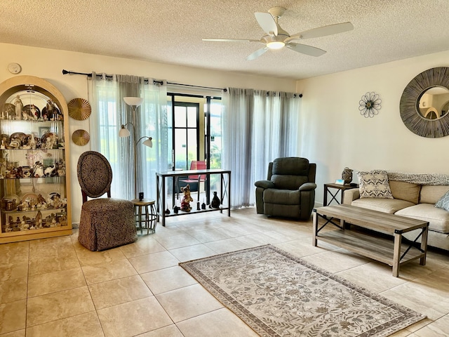 tiled living area with a textured ceiling and ceiling fan