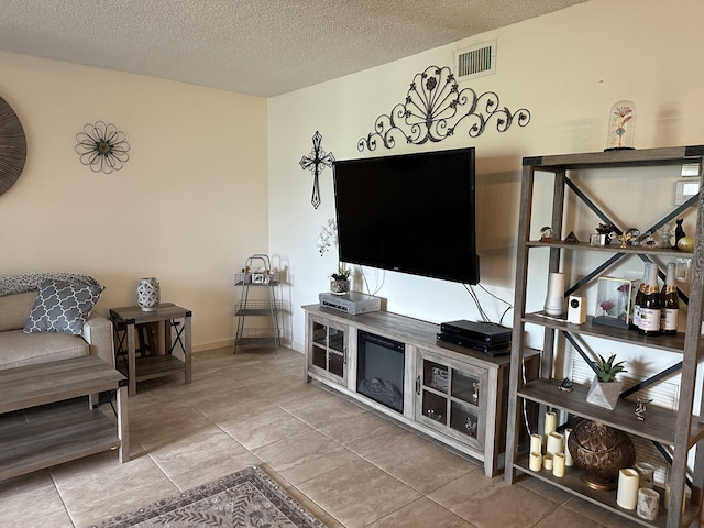 living room featuring tile patterned floors, visible vents, and a textured ceiling
