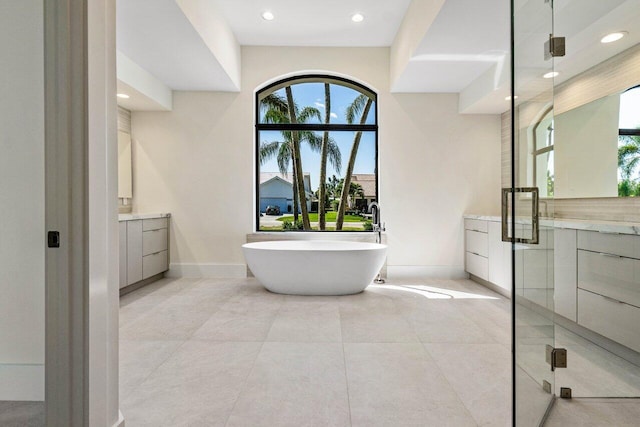 bathroom featuring vanity, baseboards, a soaking tub, recessed lighting, and tile patterned flooring