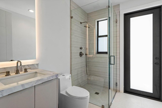 bathroom featuring a shower stall, vanity, and toilet