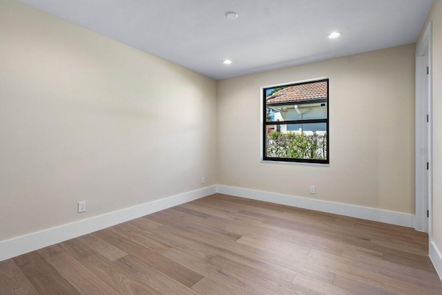 spare room with recessed lighting, baseboards, and light wood finished floors