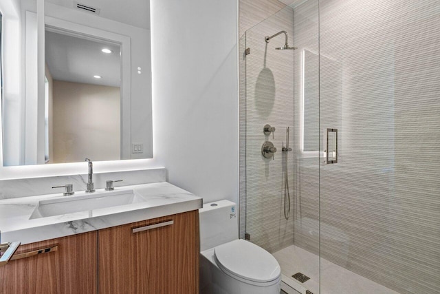 bathroom with visible vents, vanity, toilet, and a shower stall