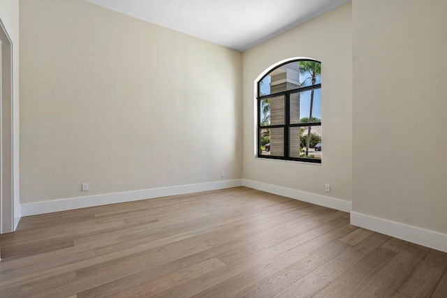 unfurnished room featuring baseboards and light wood finished floors