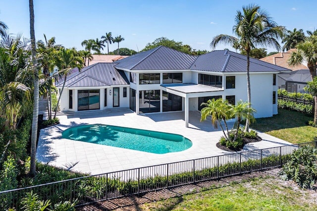 back of property featuring fence private yard, stucco siding, a patio, metal roof, and a standing seam roof