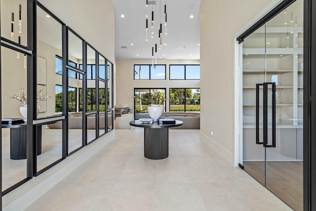 interior space featuring a high ceiling, recessed lighting, and baseboards