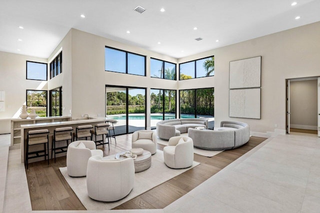 living room featuring recessed lighting, visible vents, a healthy amount of sunlight, and wood finished floors