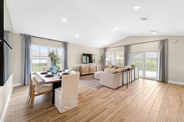 dining area with vaulted ceiling, light wood finished floors, visible vents, and a wealth of natural light