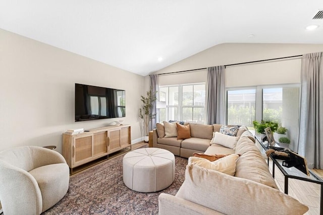 living area featuring lofted ceiling, wood finished floors, visible vents, and baseboards