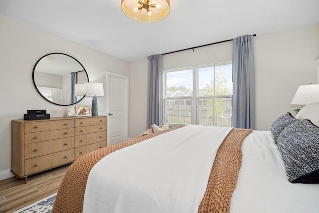 bedroom with baseboards and light wood finished floors