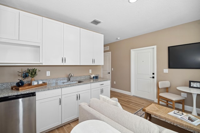 kitchen featuring dishwasher, wood tiled floor, visible vents, and a sink