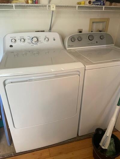 laundry room with wood finished floors and washer and clothes dryer