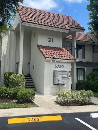 view of front of home featuring stucco siding, a tile roof, and uncovered parking