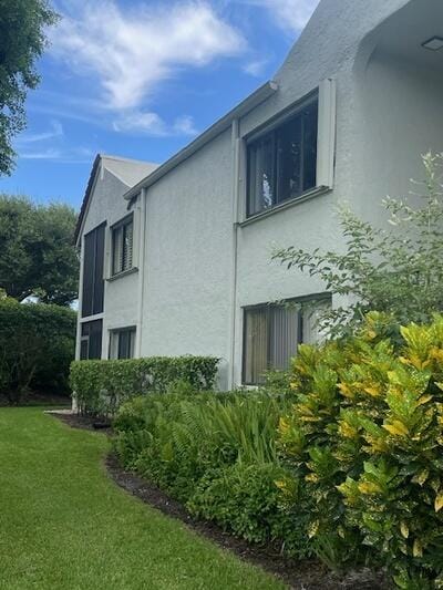 view of home's exterior with a yard and stucco siding