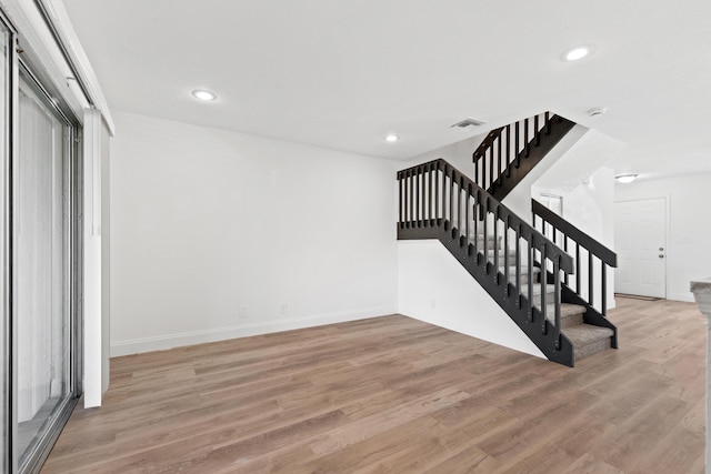 stairway with recessed lighting, wood finished floors, and baseboards