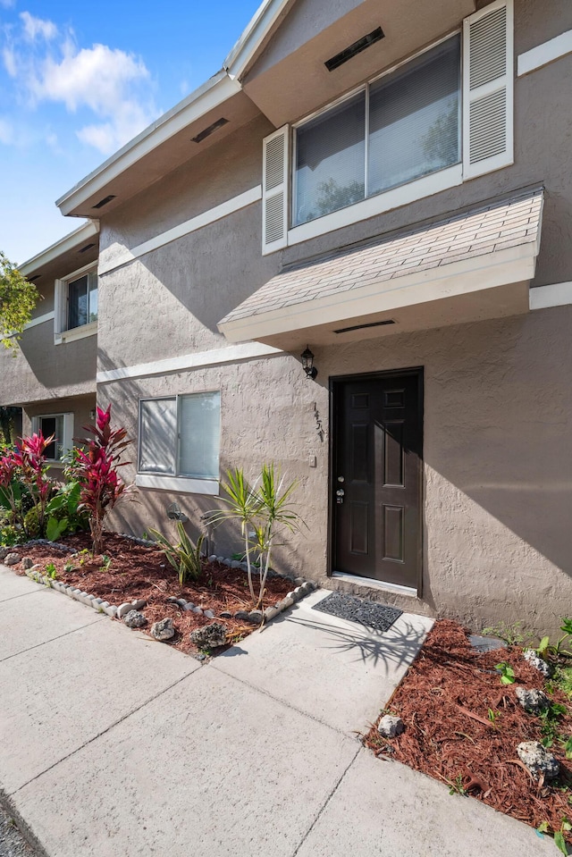 property entrance with stucco siding