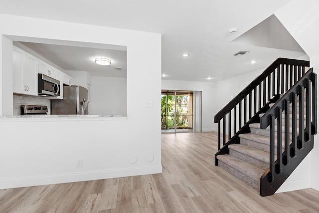 stairs featuring visible vents, recessed lighting, baseboards, and wood finished floors