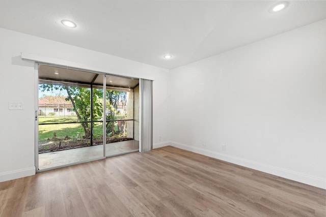 spare room with recessed lighting, baseboards, and wood finished floors