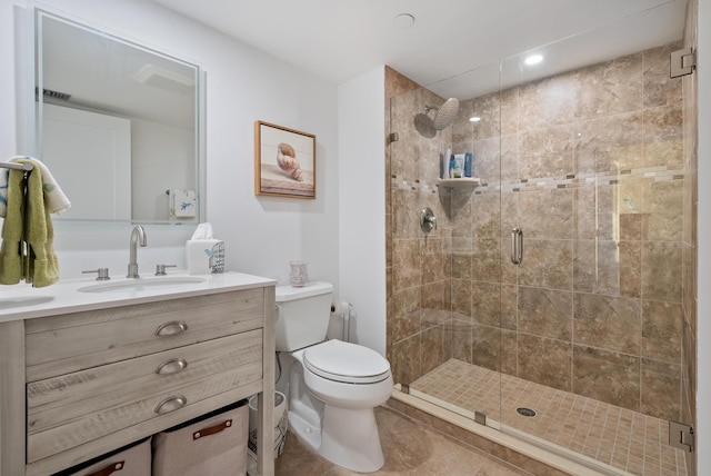 bathroom featuring tile patterned floors, toilet, a stall shower, and vanity