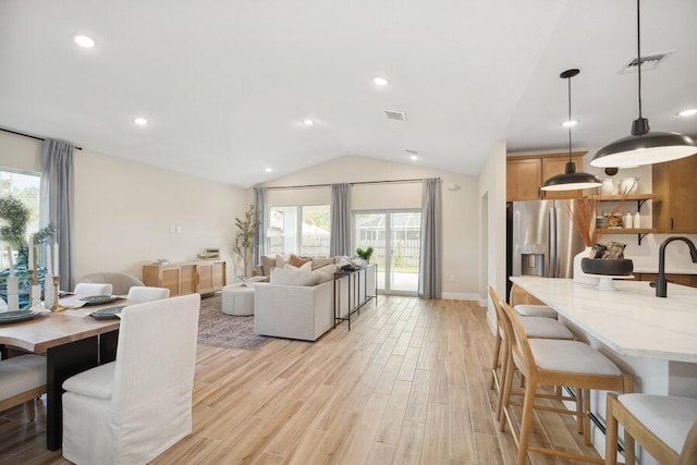 dining space featuring light wood finished floors, visible vents, recessed lighting, and vaulted ceiling